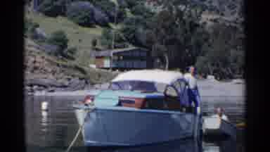 California (1955): A Man On A Large Boat Bends Over To Help A Man In A Smaller