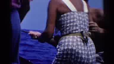 California (1955): A Darkly Tanned Woman In A Sleeveless Dress Holds A Fishing Rod