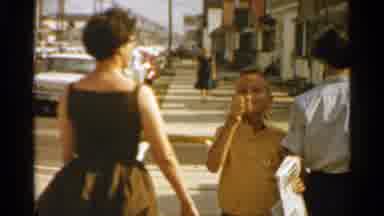 San Francisco (1959): Boy Wearing Yellow Shirt Walks Backwards Eating On A Sunny