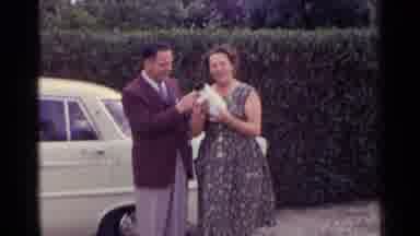 Germany (1961): Couple Holding Puppy In Front Of A Car