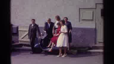 Germany (1961): Woman In Red Dress Standing With A Group Of People