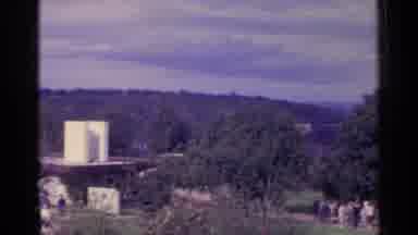 Switzerland (1961): Two House Roofs And People Walking Near The Trees