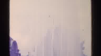 Switzerland (1961): Towering Public Water fountain By Brown Building On A Clear