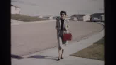 Washington DC (1962): Woman Wearing Grey Suit Walks To White Car On A Sunny Day