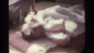 Kentucky USA (1963): A Baby Laying On A Pillow Eating From A Propped-Up Bottle Of