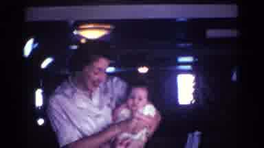 Kentucky USA (1963): Mother Smiling And Holding Baby In Dark House With Light