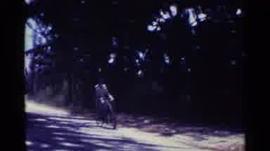 Nassau Bahamas (1963): Woman Wearing White Dress Rides Bicycle On A Sunny Day