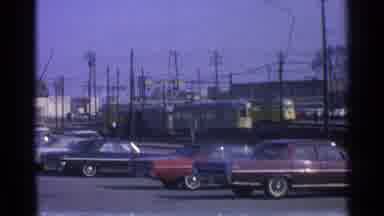 Ohio USA (1965): Two Yellow Streetcars Round A Curve While Two Women In Dress