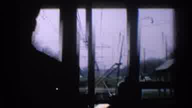 Ohio USA (1965): Yellow Electric Train Slowly Moves Down The Tracks Through A