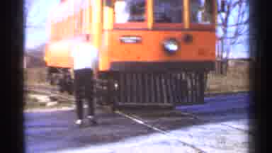 Connecticut USA (1953): A Man Stepping Up Onto A Moving Orange Small Train