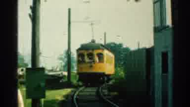 Connecticut USA (1953): A Yellow Train Riding Down A Track On A Sunny Day Around A