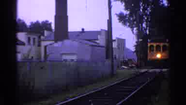 Connecticut USA (1953): A Yellow Train On A Track Moving Through A Town