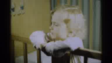 Michigan USA (1939): Frowning Toddler In Crib Looks At Camera And Moves Pillow