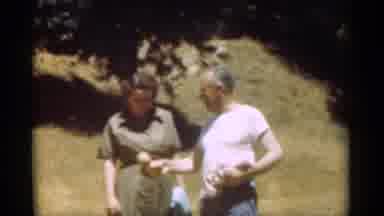 Santa Cruz California (1949): Woman Wearing Green Dress Pushes Arm Of Man Wearing