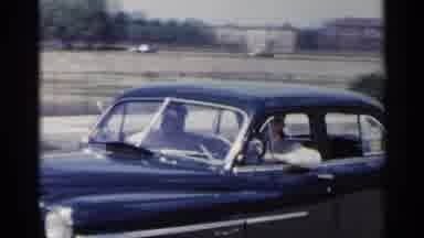 New York USA (1954): Couple Riding In Car And Woman In Dress