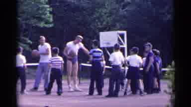 New York USA (1954): Two Adults Playing Basketball With A Group Of Kids