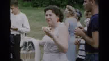 New York USA (1954): Woman Looking At The Camera While Eating A Hot Dog Surrounded