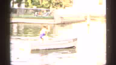 New York USA (1954): Person Wearing Black Shorts Rows White Rowboat On A Sunny Day