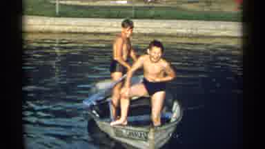 New York USA (1954): Two Kids On A Boat In The Water Standing Still Until One Boy