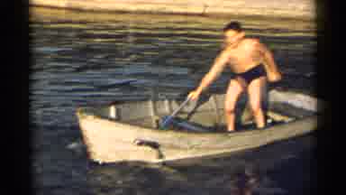 New York USA (1954): Two Young Boys Standing In A Small Boat With Paddles Then