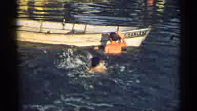 New York USA (1954): Person Wearing Black Shorts Climbs Into White Rowboat On A
