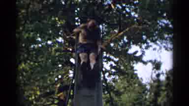 New York USA (1954): Shirtless Men Having Fun Trying To Go Down A Slide At A Park