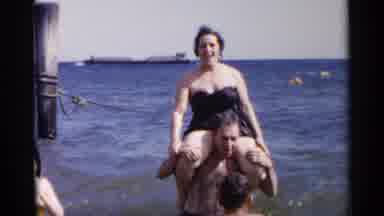 New York USA (1954): A Woman Is On A Man's Shoulder While They Play Around In The