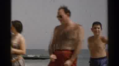 New York USA (1954): People Walking Around And Talking On The Beach As One Woman