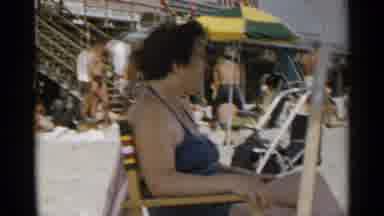 New York USA (1954): A Lady Who Is Sitting Underneath An Umbrella At The Beach To