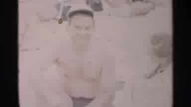 New York USA (1954): Man Wearing Black Shorts Talks To Woman Hiding From Camera