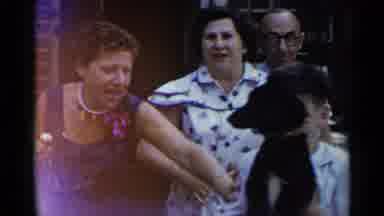 New York USA (1954): A Boy Holding A Dog And Three Adults Laughing And Playing