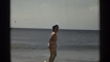 New York USA (1954): Women Playing On Beach In Front Of Sea And Old Men Watching
