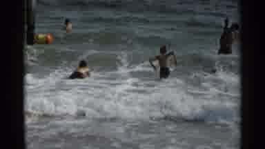 New York USA (1954): People Are Playing And Swimming In Water And A Man Is Sitting