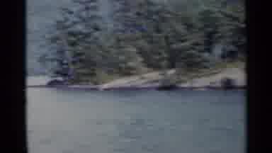 Lake George New York (1955): A Boat Navigates Down A River With Mountains Trees