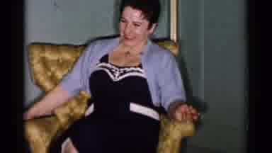 New York City (1955): A Woman Sitting In A Chair Laughing As She Plays With