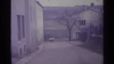 Spain (1961): Dirt Road And Tan Buildings On A Cloudy Day