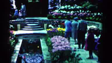 Minnesota USA (1964): People Walking Through A Flower Garden With Stairs On A