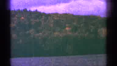 Minnesota USA (1964): A Pink Sky Rises Above A Hill Covered In Trees By A River's