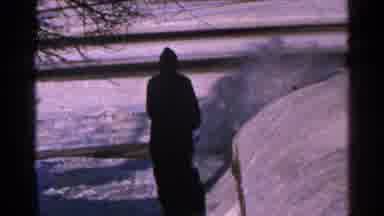 Minnesota USA (1965): Man Using A Snow Blower To Clear Snow Off Of A Walk Way By