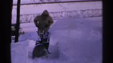 Minnesota USA (1965): A Person Using A Snowblower To Clean Their Walkway After A
