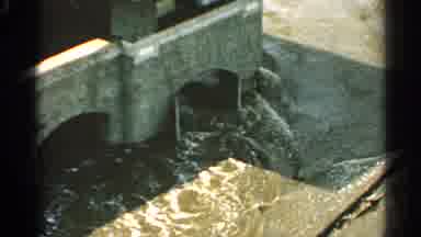 Minnesota USA-1965: Raging Floodwaters Surge Through Stone Bridge