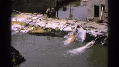 Minnesota USA (1965): Drainage Tube Water Emptying Into River Pond People Chilling