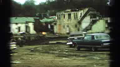Minnesota USA (1965): Yellow Car Parked On Muddy Field On A Cloudy Day