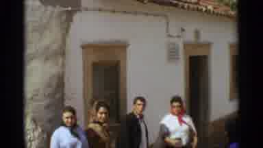 NAZARE PORTUGAL-1965: A Family In Traditional Attire Standing Outside A Village Building