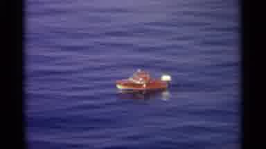 Sicily-1965: Boat Floats On Body Of Water Scene Of Mountain With Buildings On It