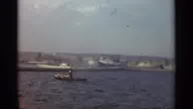 STOCKHOLM SWEDEN-1965: Tugboat Navigates Harbor With Large Ship in Background