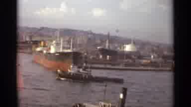 STOCKHOLM SWEDEN-1965: Ocean Liner Docked As Tugboat Maneuvers and Crowd Gathers