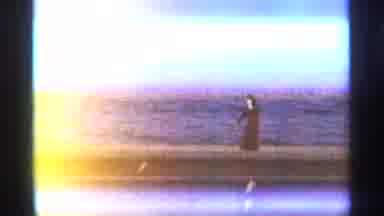 TANGIER MOROCCO-1965: A Woman In Black Walking On The Ledge Near A Large Body Of Water