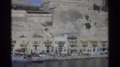 TANGIER MOROCCO-1965: A Coastal Street With Classic Cars And A Stone Fortress