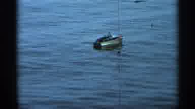 Hamel Minnesota (1966): Man Is Kneeling By Water And Sailing A Small Toy Boat